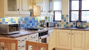 A kitchen with a microwave, toaster, stove, and sink. - 2 bedroom accommodation in Apse Wood, near Shanklin (Apse Wood, near Shanklin)