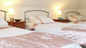 A hotel room with three beds, each with a bedside table and lamp. - 2 bedroom accommodation in Apse Wood, near Shanklin (Apse Wood, near Shanklin)