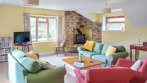 A cozy living room with a stone fireplace, a television, and comfortable seating. - 2 bedroom accommodation in Arthog, near Dolgellau (Arthog, near Dolgellau)