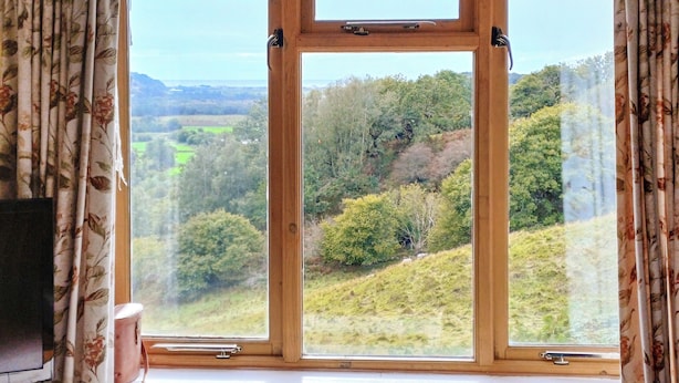 A room with a large window offering a view of a green landscape with trees and hills. - 2 bedroom accommodation in Arthog, near Dolgellau (Arthog, near Dolgellau)