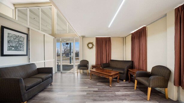 Un salon moderne avec un canapé, des fauteuils et une table basse en bois.