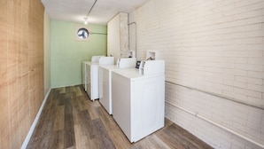 Une buanderie équipée de deux machines à laver blanches et d’un miroir au mur.