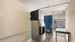 Une petite cuisine équipée comprenant un réfrigérateur intégré, un petit évier et une table en bois.