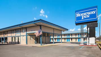 Welcome to Rodeway Inn, a two-story motel with a flat roof, offering a convenient entrance and parking.