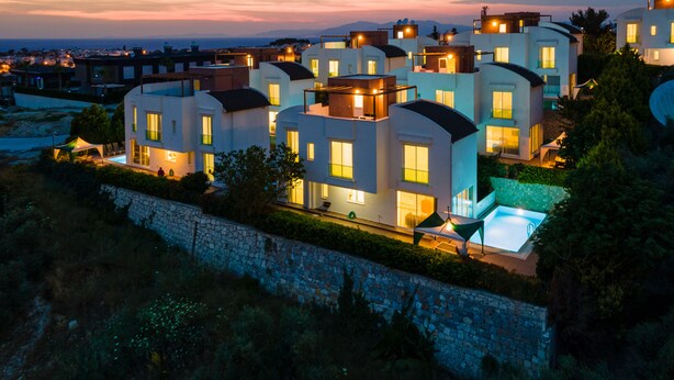 Un barrio residencial moderno con varias casas de dos pisos, con balcones y una piscina.