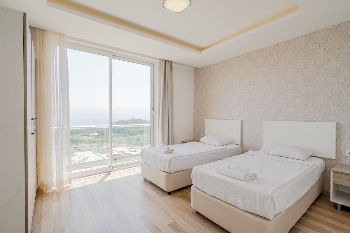 Ein Hotelzimmer mit zwei Betten, einer großen Schiebetür und Blick auf die Stadt.