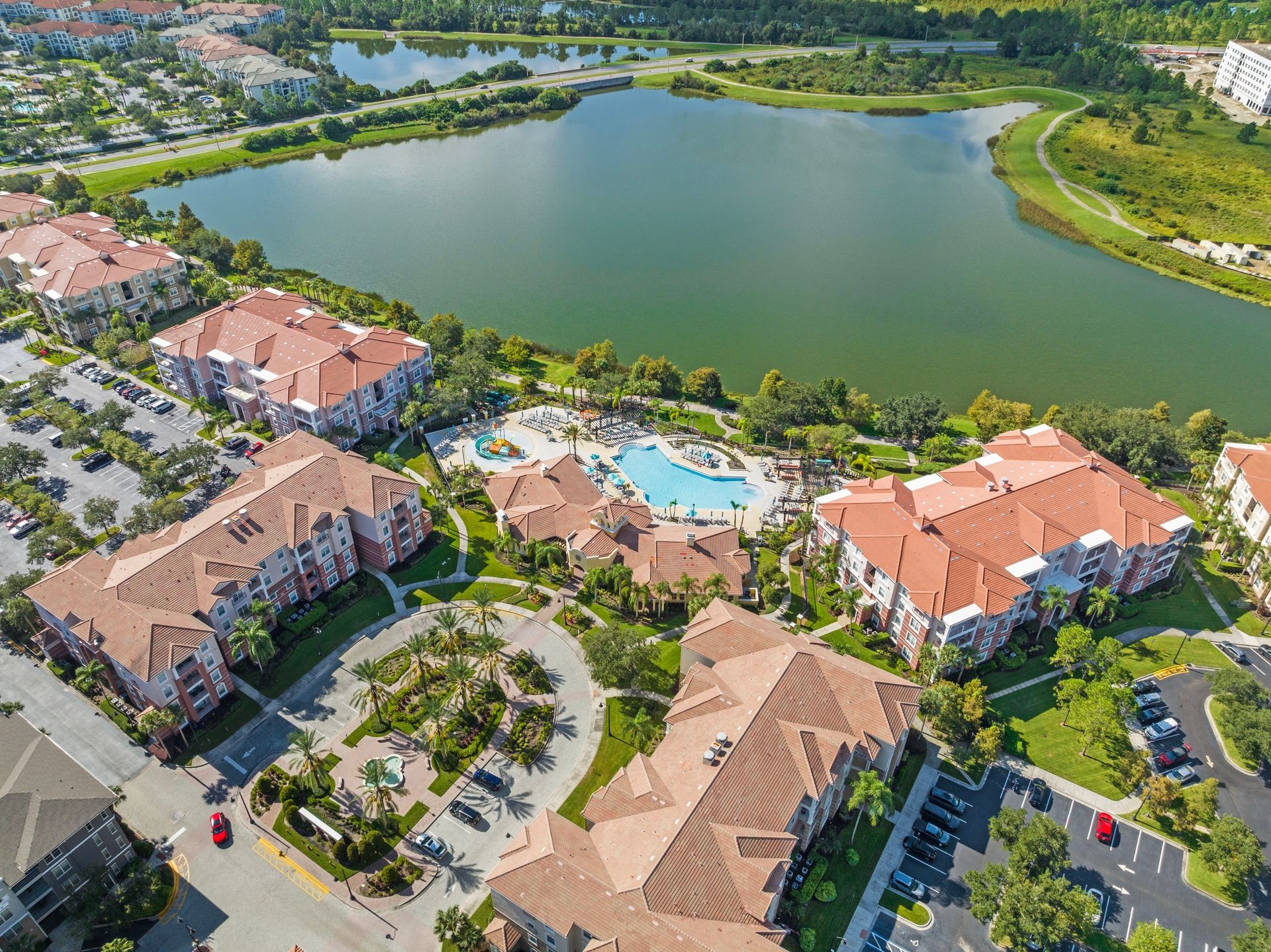 Un quartier résidentiel comprenant des immeubles d’appartements, une piscine et un lac.