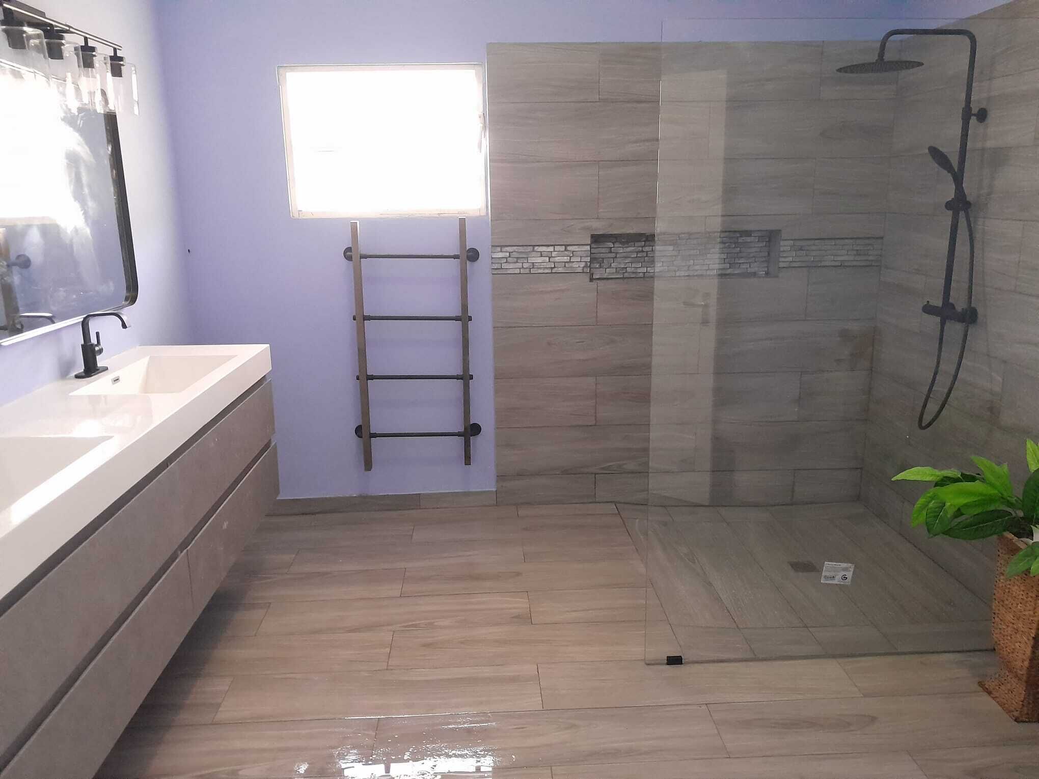 A modern bathroom with a shower, a sink, and a ladder.