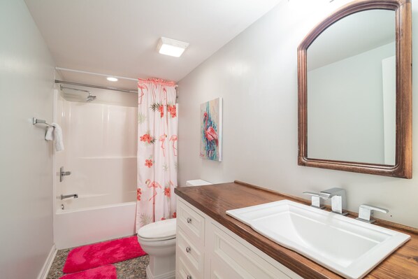 A bathroom with a bathtub, toilet, and sink.