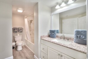 Een badkamer met douche, toilet, wastafel en badkamermeubel.
