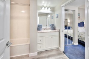Een moderne badkamer met een bad, een wastafelmeubel en een spiegel.