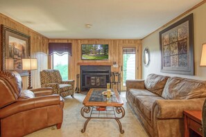 A living room with a fireplace, leather sofas, a coffee table, and framed artwork. - Powderidge #14:  2 Bedrooms, 2.5 Bath: Slope Side, Wood Fireplace. (Snowshoe)