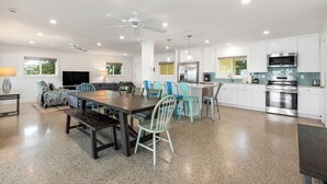 A spacious kitchen with a central island, modern appliances, and a dining area with a large table and chairs.