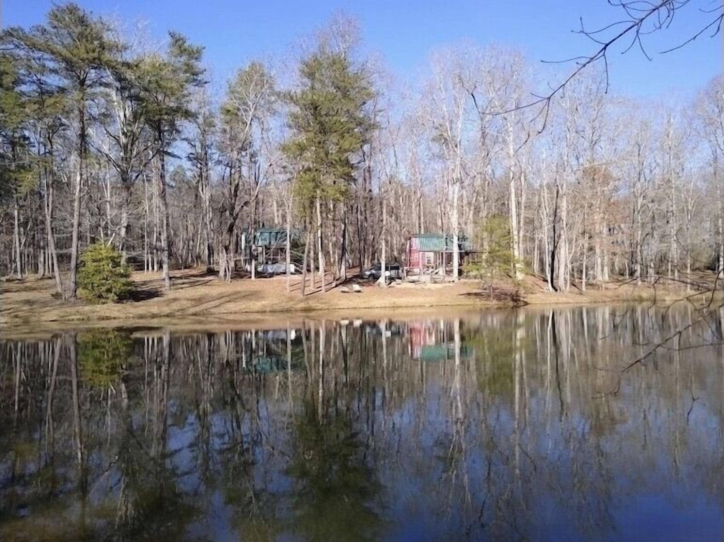 Eine Holzhütte an einem See, umgeben von Bäumen.