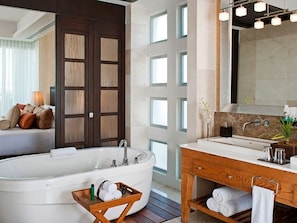 Bathroom features a bathtub, wooden vanity, and marble sink.