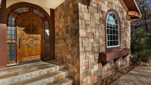 A stone house with a wooden front door and a window.