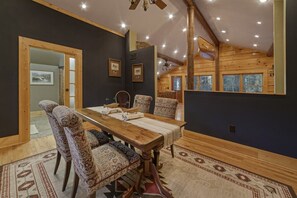 A dining area with a wooden table, patterned chairs, and a ceiling fan. - A River Runs Thru It | 3BR Riverfront| in Helen (Helen)
