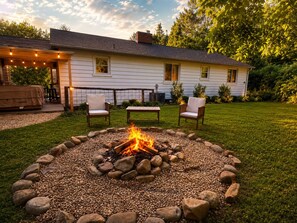 A house with a fire pit in the yard, surrounded by rocks. - Charming Asheville Cottage: HotTub+Fire pit+Fall foliage+Near DT & Biltmore. (Asheville)