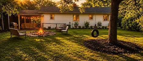 Una casa con porche cubierto, chimenea y mobiliario exterior.