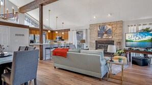 A spacious living area with a sofa, dining table, and kitchen in the background.