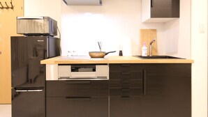 A modern kitchen with a built-in oven, a microwave, and a sink. - Shizuka - Kozu (Osaka)