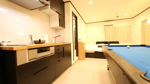 A modern kitchen with a built-in oven, a sink, and a wooden countertop. - Shizuka - Kozu (Osaka)