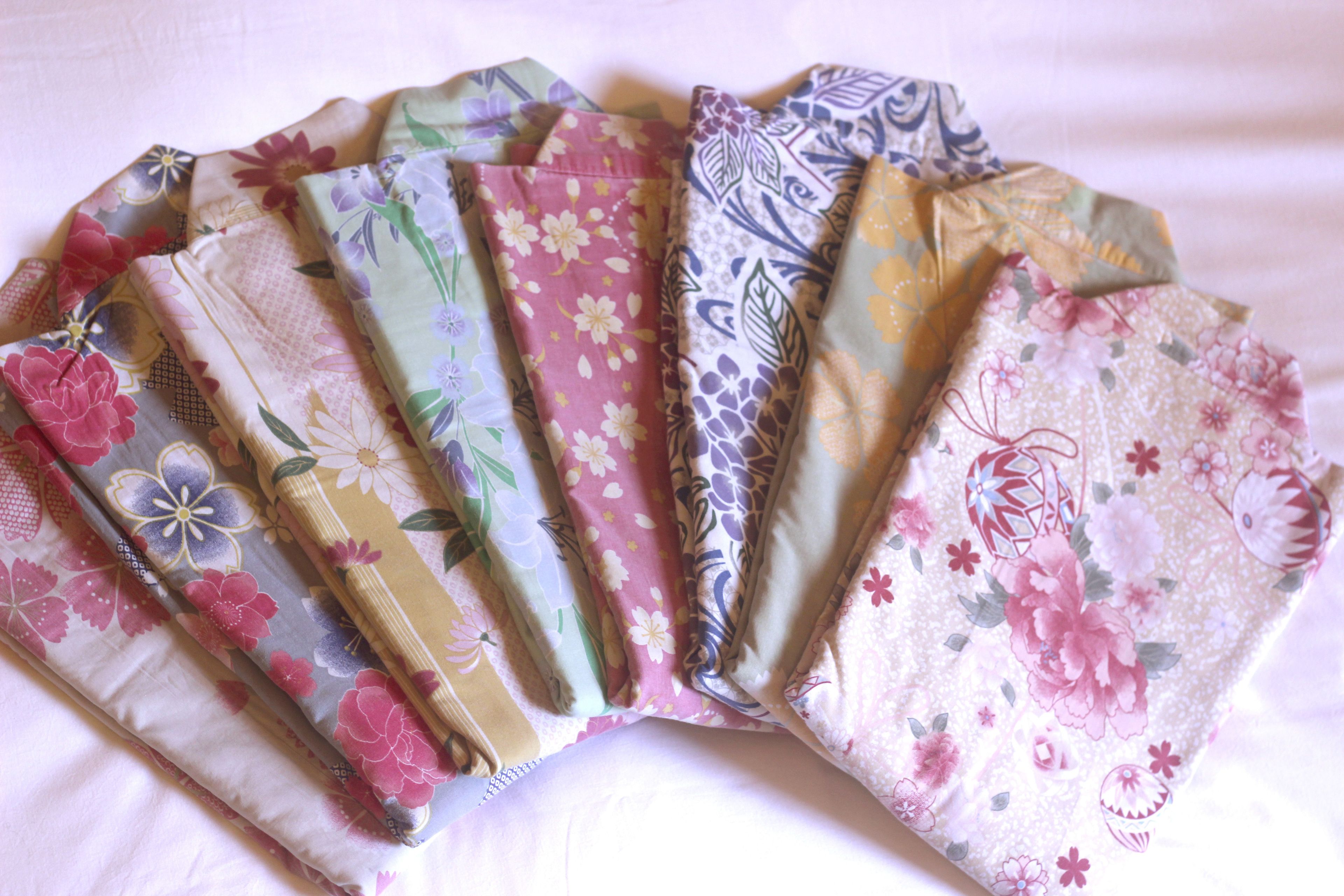 A collection of folded fabrics with floral patterns.