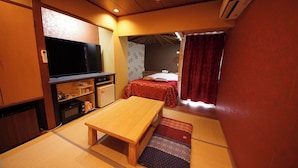 A compact hotel room with a bed, a small desk, a television, and a kitchenette. - Hotel mju - Adults Only (Tokyo)