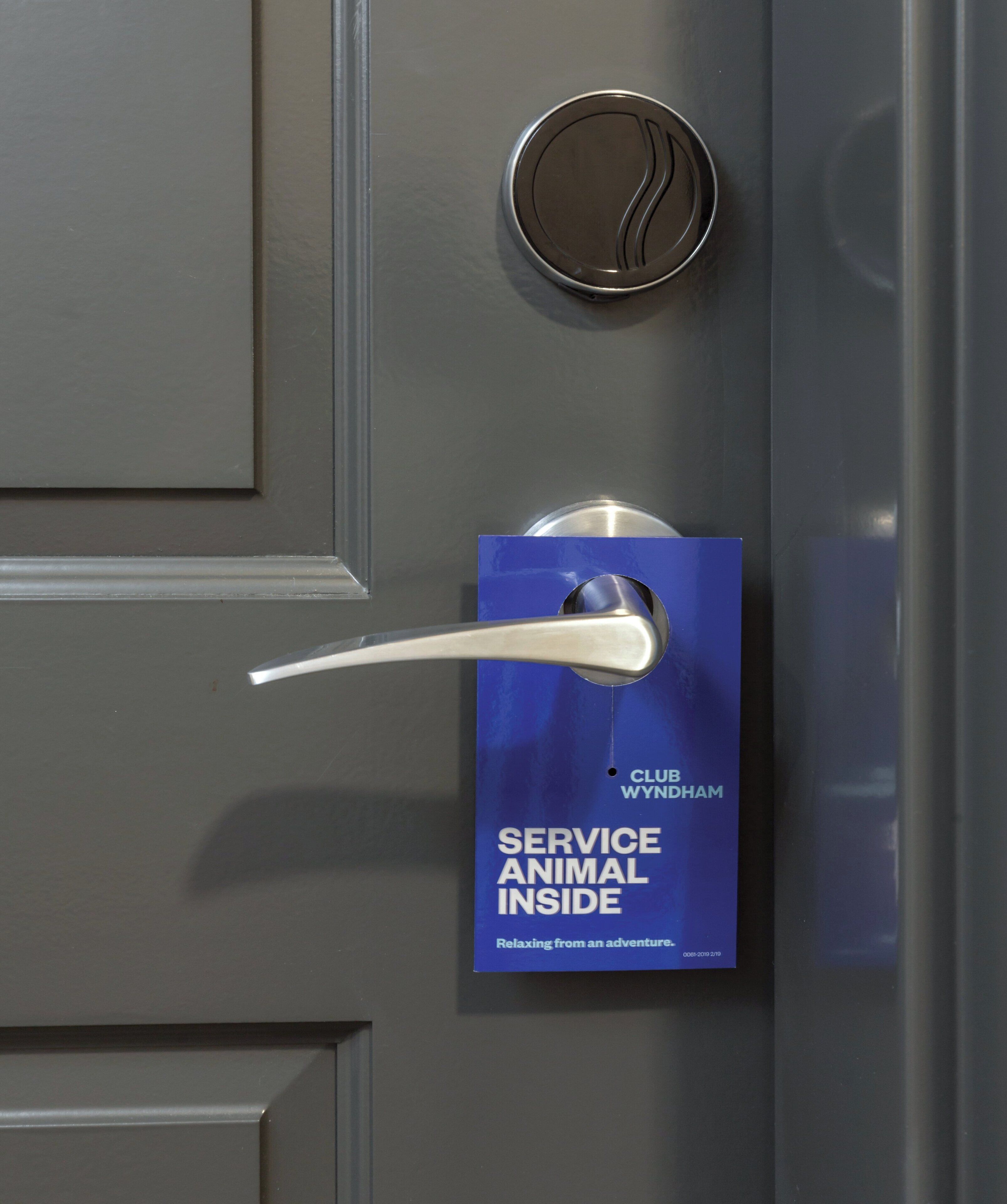 A door with a service animal sign and a key card slot.