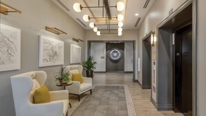 Una hall moderna con reception, area salotto e ascensori.