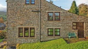 A stone building with a sloped roof, multiple windows, and a door. - 3 bedroom accommodation in Horsehouse near Leyburn (Horsehouse near Leyburn)
