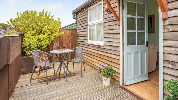 A wooden cottage with a patio, two chairs, a table, and a door. - 1 bedroom accommodation in Staithes, near Whitby (Staithes, near Whitby)