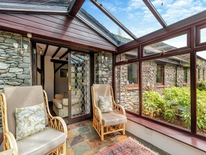 A cozy room with wicker chairs, a stone wall, and a glass ceiling. - 3 bedroom accommodation in Bampton (Bampton)