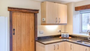 A modern kitchen with wooden cabinets, a built-in oven, and a window providing natural light. - 3 bedroom accommodation in Portland (Portland)