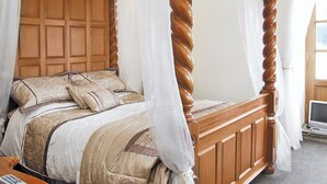 A four-poster bed with a wooden headboard and canopy, a floral-patterned bedspread, and a bedside table with a lamp. - 2 bedroom accommodation in Kennythorpe near Malton (Kennythorpe near Malton)