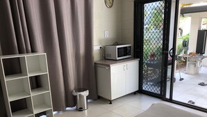 A small kitchenette with a microwave, a cabinet, and a trash bin. - Close to amenities, NBN, Swimming pool, Netflix,  (Kirwan)