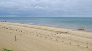 A wide sandy beach with a calm sea under a cloudy sky. - 2 bedroom accommodation in Walcott (Walcott)