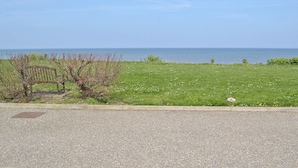 A gravel path leading to a grassy area with a bench and a view of the sea. - 2 bedroom accommodation in Walcott (Walcott)