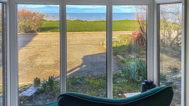 A room with a large window offering a view of a grassy field and a body of water. - 2 bedroom accommodation in Walcott (Walcott)
