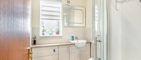 Ein modernes Badezimmer mit Toilette, Waschbecken und Duschkabine aus Glas.