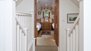 A narrow hallway with a carpeted staircase leading to a bedroom. - 3 bedroom accommodation in Bromeswell, Woodbridge (Bromeswell, Woodbridge)