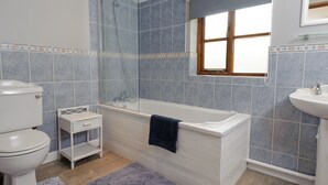 A bathroom with a bathtub, toilet, and sink. - 3 bedroom accommodation in Bromeswell, Woodbridge (Bromeswell, Woodbridge)