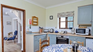 A compact kitchen with a dining area, featuring a microwave, toaster, and a small sink. - 3 bedroom accommodation in Bromeswell, Woodbridge (Bromeswell, Woodbridge)