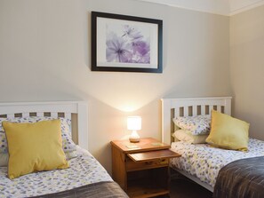 A bedroom with two beds, each with a pillow and a bedside table with a lamp. - 2 bedroom accommodation in Bournemouth (Bournemouth)