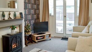 A living room with a fireplace, a television, a bookshelf, and a sofa.