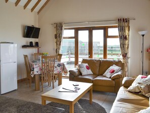 A cozy living room with a sofa, coffee table, and dining area.