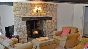 A cozy living room with a stone fireplace, two armchairs, a sofa, and a flat-screen TV. - 3 bedroom accommodation in Winterbourne Steepleton, near Dorchester (Winterbourne Steepleton, near Dorchester)