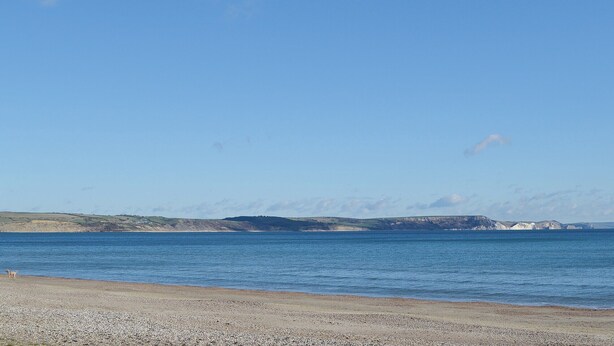 A coastal landscape with a pebbly beach and a calm sea. - 3 bedroom accommodation in Winterbourne Steepleton, near Dorchester (Winterbourne Steepleton, near Dorchester)