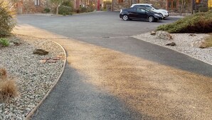 A stone building with a paved driveway and a parked car. - 2 bedroom accommodation in Padstow (Padstow)