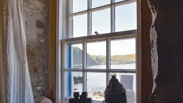 A room with a large window overlooking a coastal landscape. - 2 bedroom accommodation in Crovie, Gardenstown (Crovie, Gardenstown)